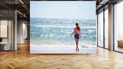 Tween red haired girl in swimsuit at the beach. Wall mural