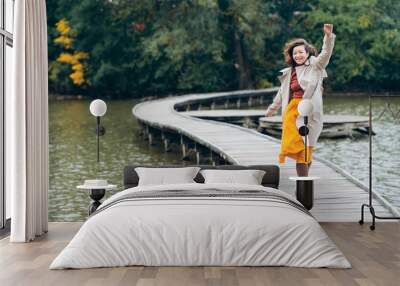 Woman walking on a bridge on a lake in autumn in Prague Wall mural