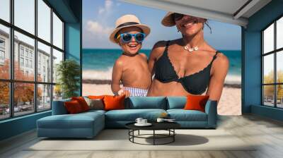 Young latin baby boy wearing a hat and sunglasses at the beach Wall mural