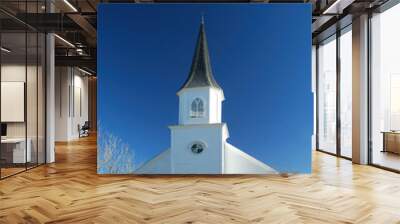 Community church is pristine white against a dark blue sky. Wall mural