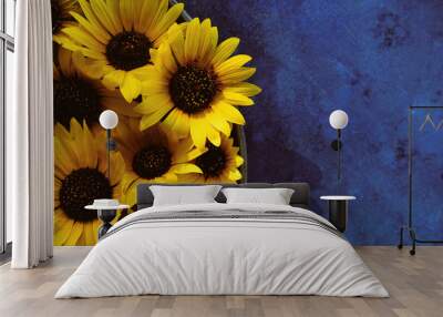 Group of yellow sunflower flowers on blue texture background, copy space for summer sale concept or mother's day. Wall mural