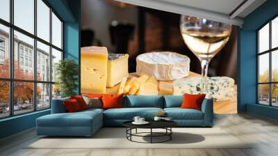 detail of a wooden board with cheese to eat on a restaurant table with a glass of wine Wall mural