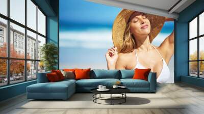 Summer, hat and face of woman on beach, vacation or relax on holiday in sun, sea and blue sky with ocean. Happy, girl in bikini and healthy glow, skin and travel to tropical nature or Florida Wall mural