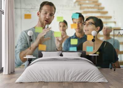 Planning is the first step. Cropped shot of a group of young designers planning on a glass board. Wall mural