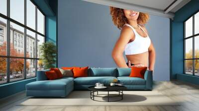 Sports, beauty and portrait of confident black woman with happy face and mockup on blue background. Fitness, health and wellness, woman with afro with smile, motivation and healthy mindset in studio. Wall mural