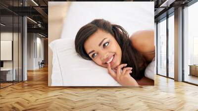 Feeling a little shy. Shot of a gorgeous young woman posing seductively on her bed. Wall mural