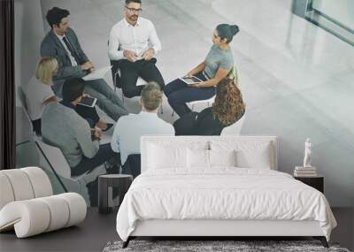 Support, care and unity by colleagues in a business meeting, sitting together in a modern office. Above a creative team brainstorming, planning and sharing an idea or goal while huddled in a circle Wall mural