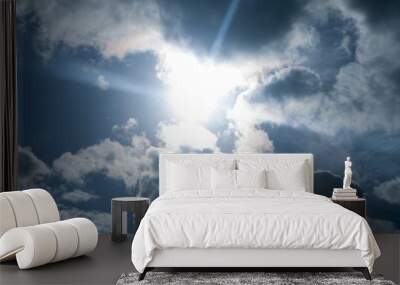 Blue sky with fluffy clouds and sun peeping through Wall mural