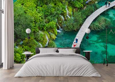 Tourists walk by wooden path, in the Plitvice Lakes National Park  which is a UNESCO World Heritage site. Wall mural