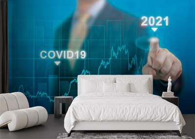 global economy concept of economic recovery after the fall due to the covid 19 coronavirus pandemic. Businessman pointing graph corporate future growth plan on dark blue Wall mural