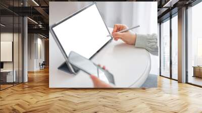 woman working on digital tablet with stylus and phone. female entrepreneur checking few financial reports on mockup tablet computer Wall mural