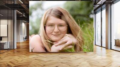 teenage girl relax and lying on grass and look in camera. world children's day content Wall mural