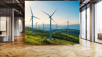 Wind turbines on a green hill with a bright blue sky in the background. Wall mural