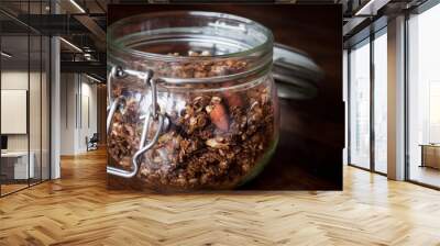 A jar of home made ginger bread granola on to a wooden table top. This granola is made from roasted oats with ginger,cinnamon and almonds for a delicious breakfast. Wall mural