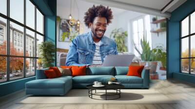 Smiling Young Man Working on Laptop in Home Office Wall mural