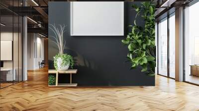 A minimalist living room interior with a blank square frame on a dark wall. wooden side table with plants. and hardwood floor Wall mural