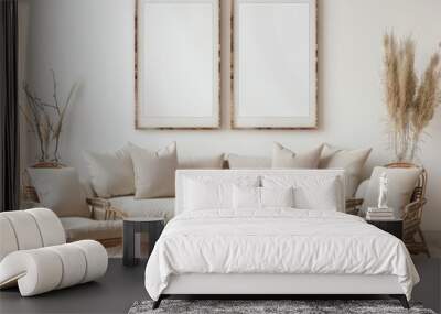 A minimalist living room with a white couch. two chairs. two empty picture frames. and a woven rug Wall mural