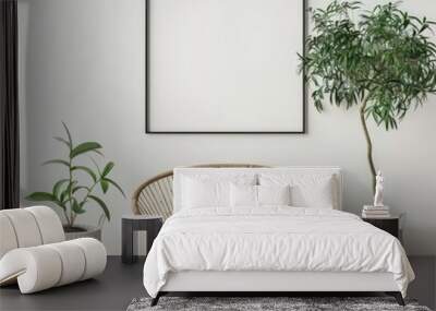 A stylish living room interior with a rattan chair. two potted plants. and a large black framed picture on a white wall Wall mural