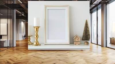 Elegant white frame mockup on a white fireplace mantel with gold candlesticks and christmas decor. Portrait orientation Wall mural