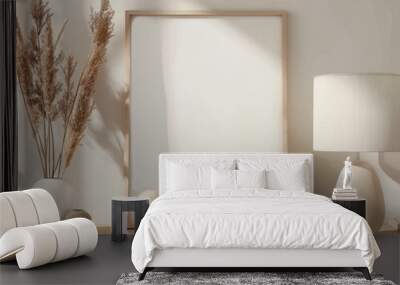 Minimalist interior design with a blank frame mockup on a wooden sideboard. Sunlight shadows on a white wall, pampas grass in a vase, and a modern table lamp Wall mural