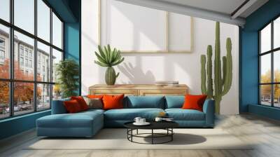 Minimalist living room interior with a wooden cabinet. a cactus plant. and two empty picture frames Wall mural