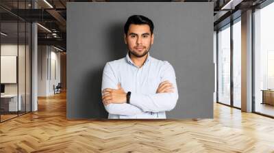 elegant hispanic businessman crossing his arms. young latino in studio Wall mural