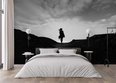 silhouette of woman on top of mountain Wall mural