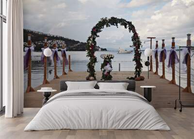 Wedding decoration at a pier by the beach with flowers Wall mural