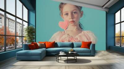 a little girl holding a heart shaped lollipop Wall mural