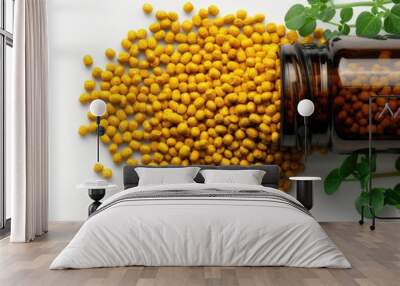 A jar of yellow seeds is on a white background Wall mural