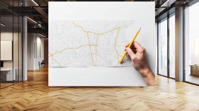 A person holding a pencil and a map, symbolizing the journey of learning. Wall mural