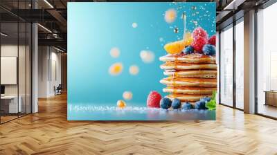 A stack of whole grain pancakes topped with fresh fruit and maple syrup Wall mural