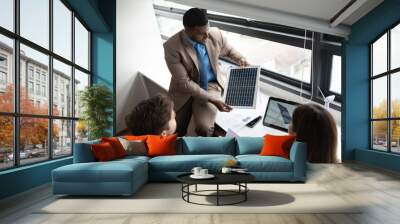 African American businessman and team business working with solar panel and tablet computer at office Wall mural