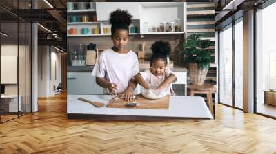 Happy child black skin thresh flour in kitchen Wall mural