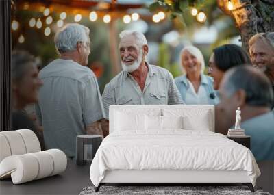 Group of senior people having dinner together at a summer party. They are smiling and talking. Wall mural