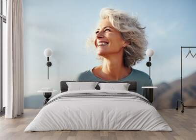 Outdoor portrait of a beautiful middle aged woman smiling and looking up Wall mural