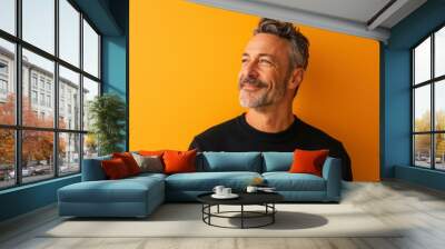 Portrait of a handsome middle-aged man on a yellow background Wall mural