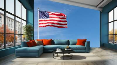 Beautiful American flag waving in the wind, with vibrant red white and blue colors against blue sky, with copy space. Wall mural