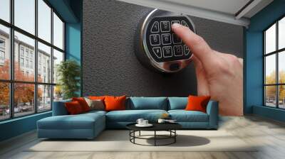 Hand enters combination on digital lock on a safe Wall mural