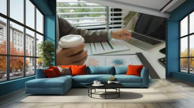 a businessman is in his private office and working with a lot of paperwork, a senior executive of marketing company is checking income report of this year, analyzing document Wall mural