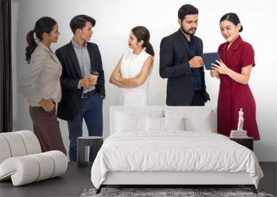 Team of successful young people standing together. Some people drink coffee some people using tablet computer. Portrait on white background with studio light. Wall mural