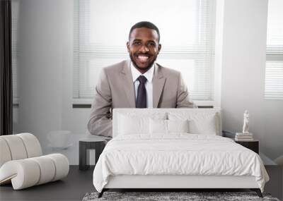 Happy handsome african american businessman smiling while looking at camera in office Wall mural