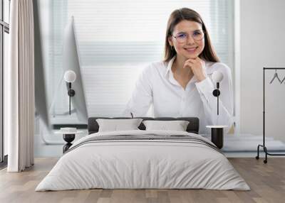 Portrait of business woman looking at camera at workplace in an office Wall mural