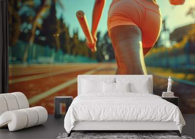 Action shot of a runner during a relay race, passing the baton with precision and teamwork, ideal for sportswear and fitness promotions. Wall mural