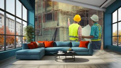 Two young man architect on a building construction site Wall mural