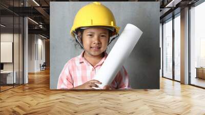 Portrait kid wearing hard hat yellow holding holding a blueprint. To learning and enhance development, little architect. Wall mural