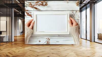 Top view of two hands holding blank white paper frame on old wooden background for mockup Wall mural