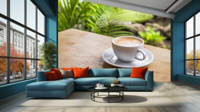 Cup of coffee on brown wooden table at coffee shop. Hot cappuccino the best start to any morning at cafe with copy space. Wall mural