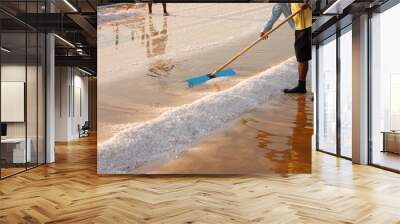 Workers use tools to produce salt that comes from the sea. Wall mural