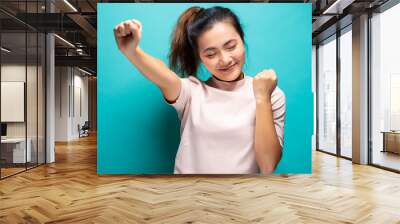 Happy woman standing isolated over blue background Wall mural